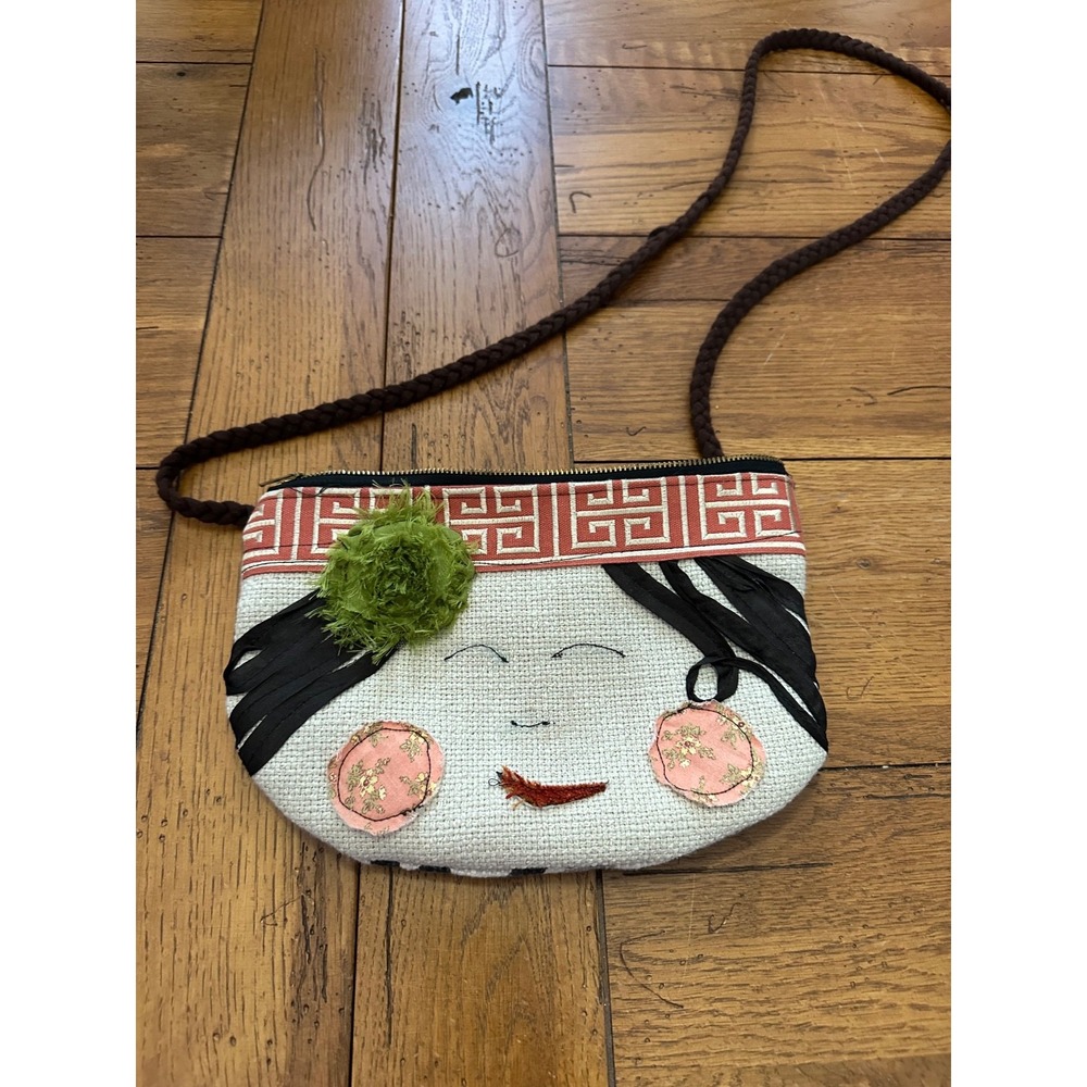 small patchwork purse with‎ face embellishments